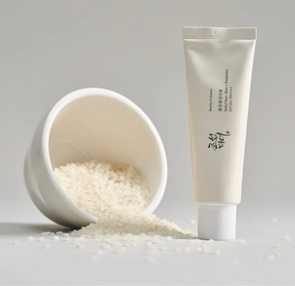Tube of cream next to a bowl filled with white granules on a light gray background