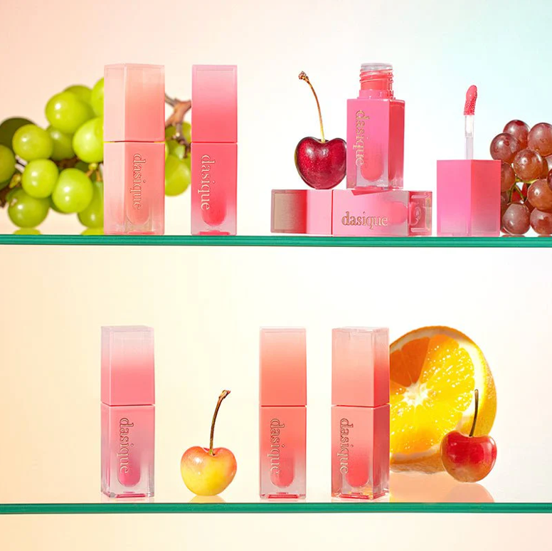 Collection of pink lip products with cherries and grapes on a shelf