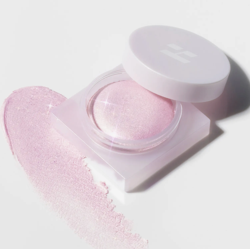Pink cosmetic product in an open container on a light background; Holika Holika Luminous Milk Beam Pot highlighter for Korean glow makeup
