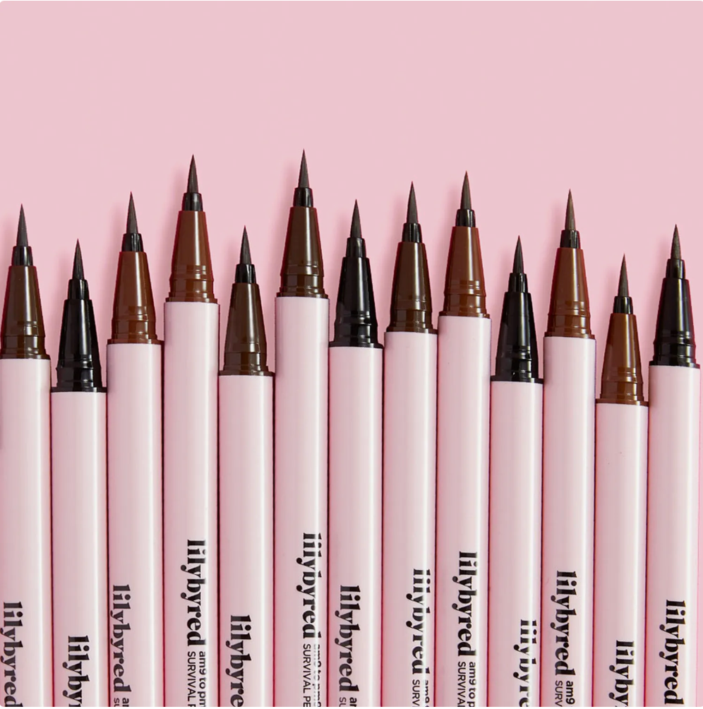 Row of lilybyred survival pens with various tip colors on a pink background
